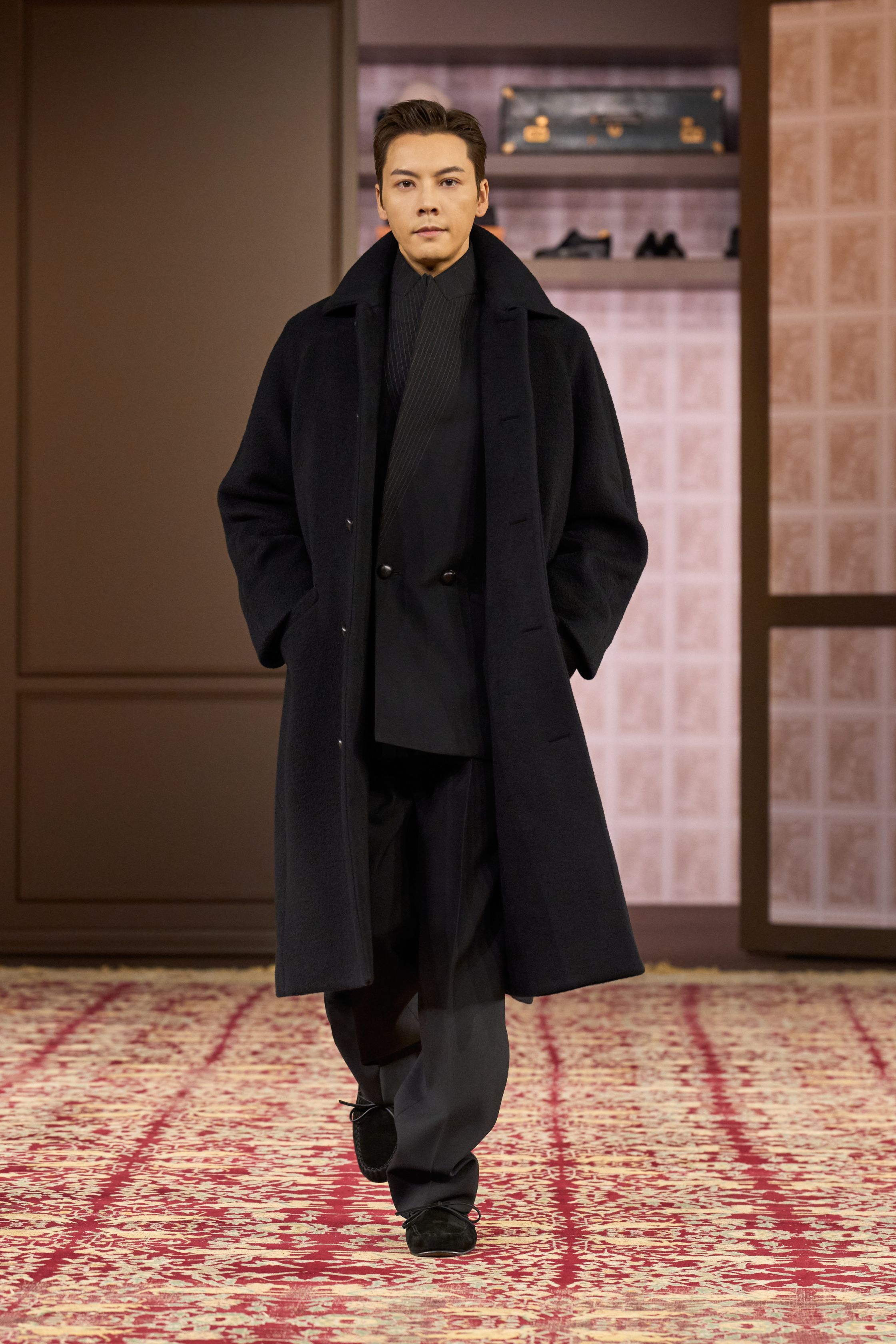 ZEGNA 2026秋冬以“安静权威”为核心命题，在高度私密、近乎沙龙式的空间中重塑当代男性精英形象。柔和灯光下，西装、大衣与针织被处理得异常克制，廓形松弛却精准，强调肩线的自然下垂与裤装的流动垂感。羊毛、羊绒与精纺面料成为绝对主角，色彩集中于驼色、烟灰、深橄榄与夜黑，传递一种无需证明的自信。这一季ZEGNA不谈趋势，而是提出一种长期有效的男性着装秩序——成熟、内敛、经得起时间审视的“当代绅士体系”-顽石频道趋势研究